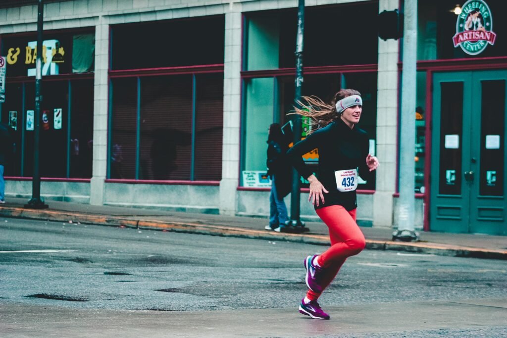 A woman in sportswear runs in a city marathon, showcasing fitness and determination.
